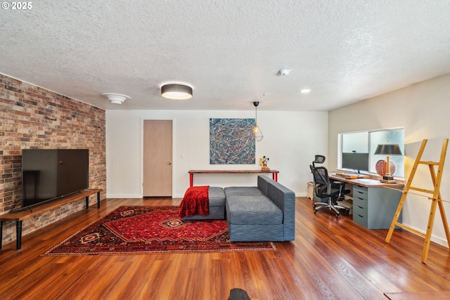 living room with baseboards, a textured ceiling, and wood finished floors