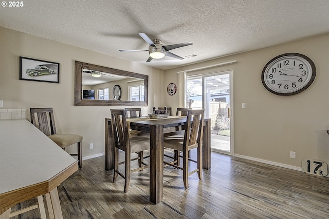 dining space featuring ceiling fan, dark hardwood / wood-style floors, and a textured ceiling