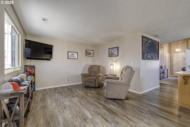 living area featuring a textured ceiling and hardwood / wood-style flooring