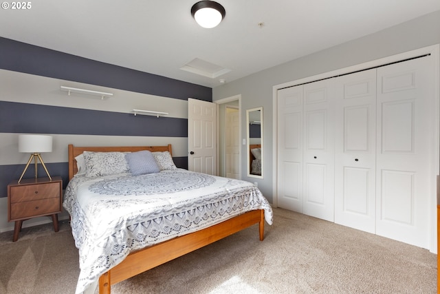 bedroom featuring a closet, attic access, and carpet floors