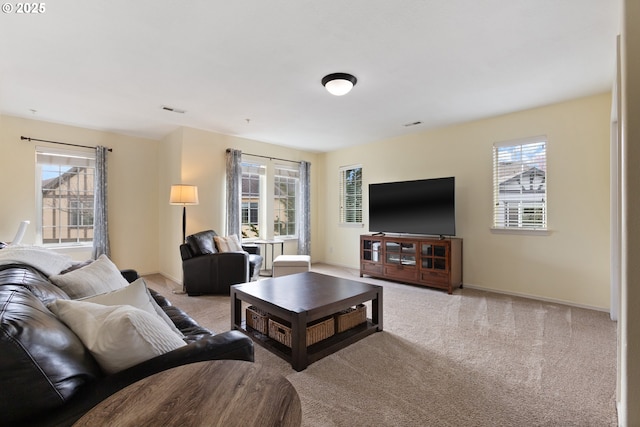 living room featuring carpet flooring, baseboards, a healthy amount of sunlight, and visible vents