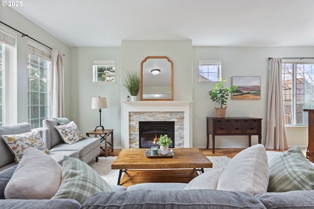 living room with a fireplace, baseboards, and a healthy amount of sunlight