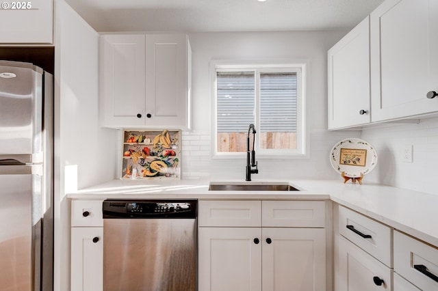 kitchen featuring appliances with stainless steel finishes, a sink, and white cabinetry