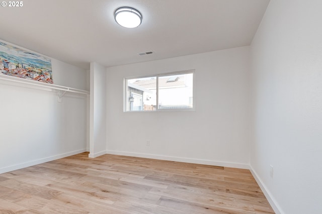 unfurnished bedroom featuring light wood finished floors, a closet, visible vents, and baseboards