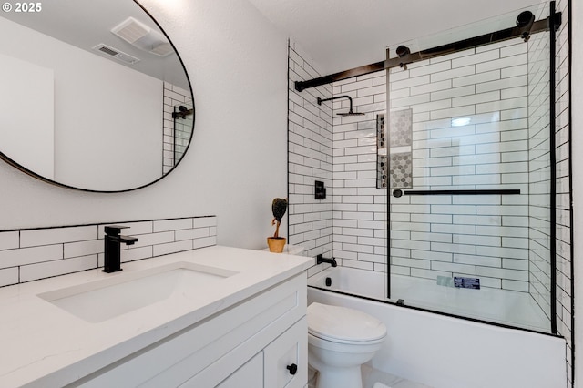 full bathroom with toilet, vanity, visible vents, combined bath / shower with glass door, and decorative backsplash