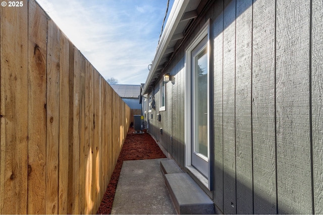 view of home's exterior featuring central AC unit and fence