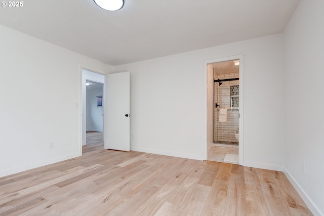 empty room featuring light wood-type flooring and baseboards