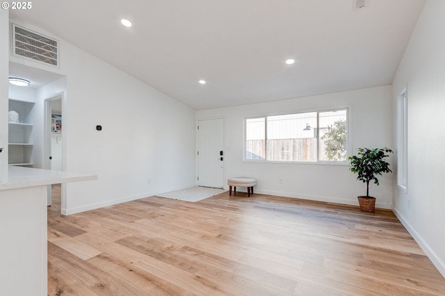 spare room with light wood finished floors, baseboards, visible vents, and recessed lighting