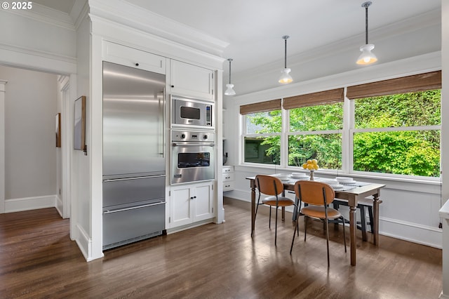 2225 NE 22nd Ave, Portland, OR 97212 - kitchen with built in appliances, crown molding, dark wood-style flooring, white cabinetry, and pendant lighting