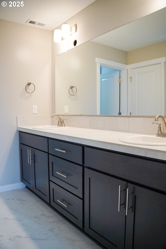 full bath with marble finish floor, double vanity, a sink, and visible vents