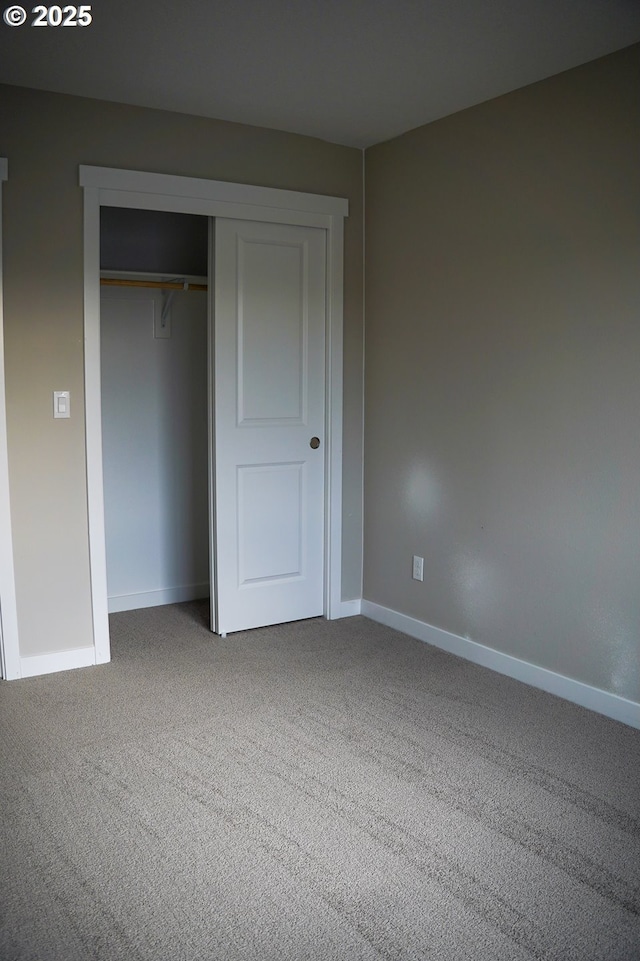 unfurnished bedroom featuring a closet, carpet, and baseboards