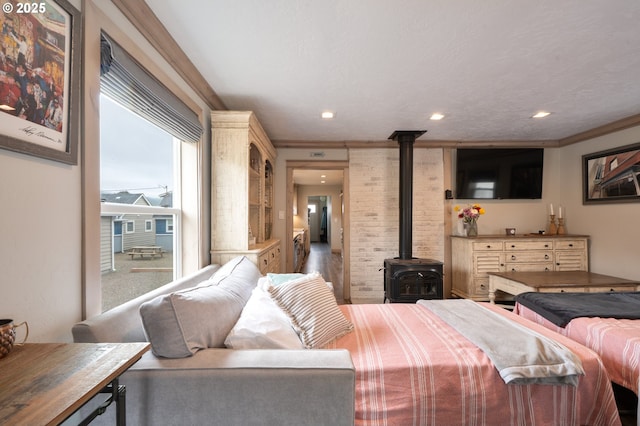 128 NW 20th Ave, Rockaway Beach, OR 97136 - bedroom with a wood stove, recessed lighting, and ornamental molding