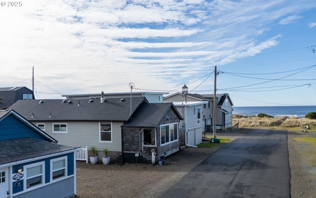 128 NW 20th Ave, Rockaway Beach, OR 97136 - rear view of property with a shingled roof, driveway, and a water view