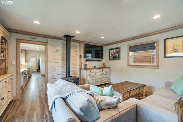 128 NW 20th Ave, Rockaway Beach, OR 97136 - living area featuring a wood stove, crown molding, wood finished floors, recessed lighting, and baseboards