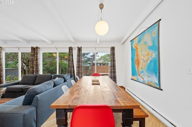 dining area featuring beam ceiling, baseboard heating, and light wood finished floors