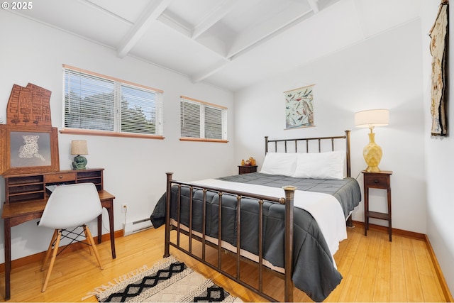 bedroom with beam ceiling, light wood-style flooring, a baseboard heating unit, and baseboards