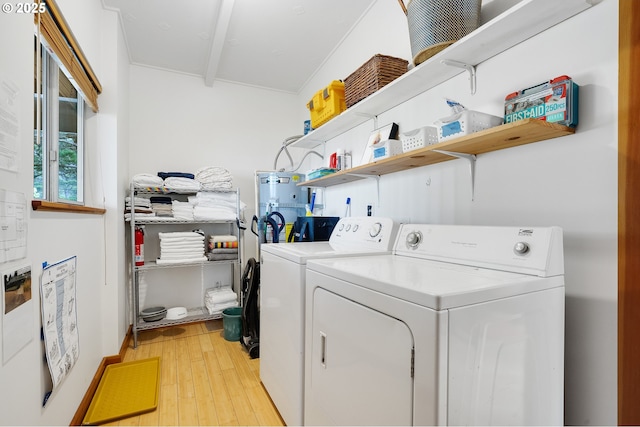 laundry area featuring washing machine and clothes dryer, laundry area, and light wood-type flooring