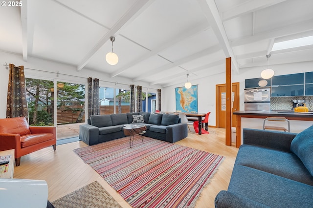 living area with vaulted ceiling with beams and light wood finished floors