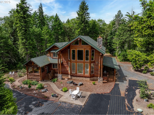 400 Rockinghorse Dr, Grants Pass, OR 97527 - cabin featuring a chimney, a patio, roof with shingles, and a forest view