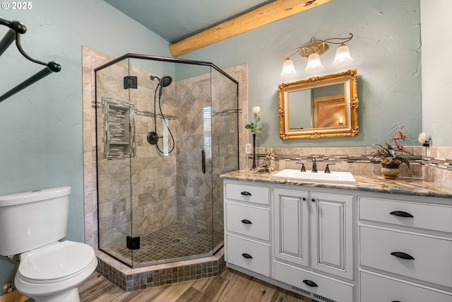 400 Rockinghorse Dr, Grants Pass, OR 97527 - full bathroom with wood finished floors, a stall shower, vanity, beam ceiling, and toilet