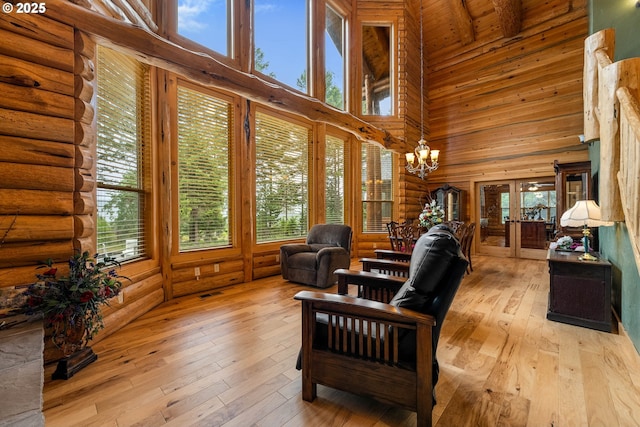 400 Rockinghorse Dr, Grants Pass, OR 97527 - living area featuring a high ceiling, log walls, french doors, healthy amount of natural light, and hardwood / wood-style flooring