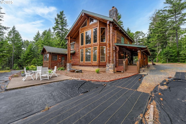 400 Rockinghorse Dr, Grants Pass, OR 97527 - rear view of property featuring a chimney, log siding, and a patio area