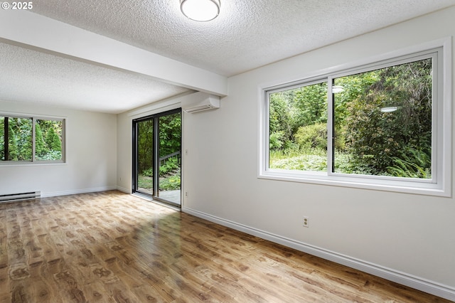 7124 SW Murray Blvd, Beaverton, OR 97008 - empty room featuring healthy amount of natural light, a textured ceiling, wood finished floors, and baseboards