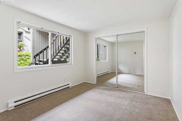 7124 SW Murray Blvd, Beaverton, OR 97008 - unfurnished bedroom with a baseboard heating unit, multiple windows, carpet, and a textured ceiling