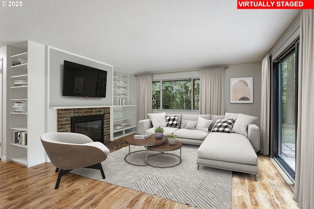 7124 SW Murray Blvd, Beaverton, OR 97008 - living area with a textured ceiling, wood finished floors, built in features, and a brick fireplace