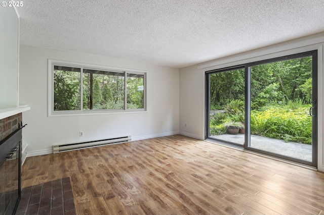 7124 SW Murray Blvd, Beaverton, OR 97008 - unfurnished living room with baseboard heating, healthy amount of natural light, wood finished floors, a textured ceiling, and baseboards