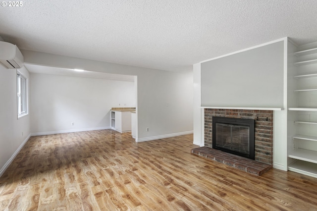 7124 SW Murray Blvd, Beaverton, OR 97008 - unfurnished living room featuring an AC wall unit, a textured ceiling, wood finished floors, a fireplace, and baseboards