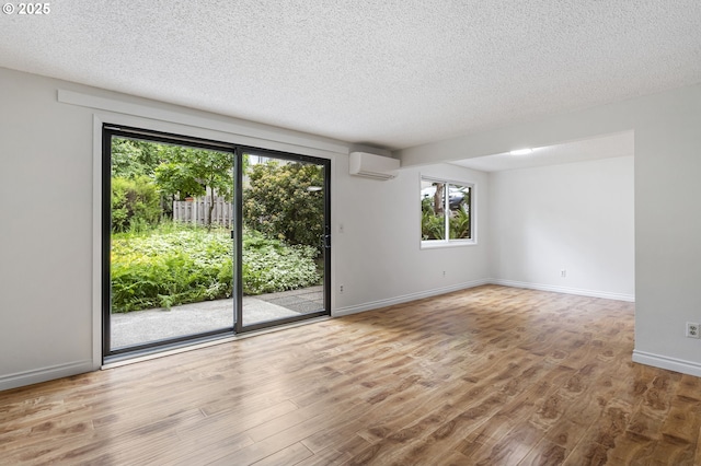 7124 SW Murray Blvd, Beaverton, OR 97008 - spare room featuring a wall mounted air conditioner, a textured ceiling, wood finished floors, and baseboards