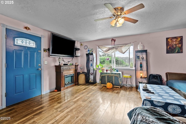 5053 NE 50th St, Neotsu, OR 97364 - living room with a textured ceiling, wood finished floors, ceiling fan, and a fireplace