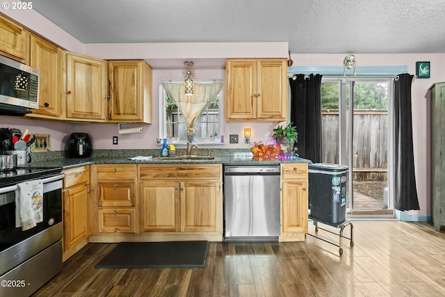 5053 NE 50th St, Neotsu, OR 97364 - kitchen featuring stainless steel appliances, dark wood-style floors, a textured ceiling, and dark stone counters