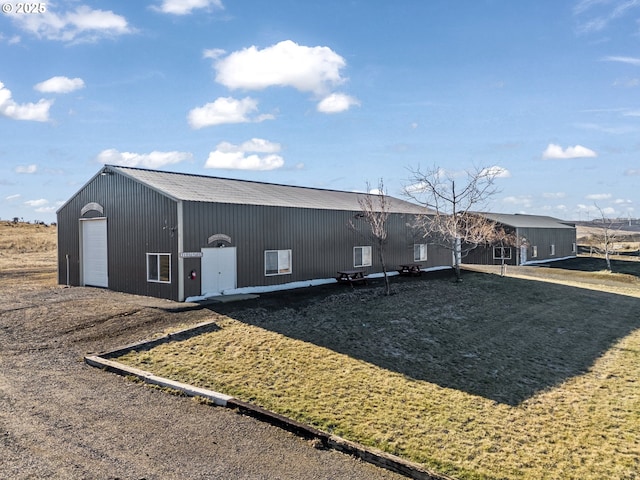 exterior space featuring a garage, an outdoor structure, and a front lawn