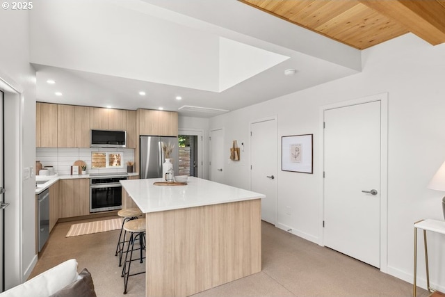 2415 NE 38th Ave Unit B, Portland, OR 97212 - kitchen featuring appliances with stainless steel finishes, modern cabinets, a breakfast bar area, light brown cabinets, and recessed lighting