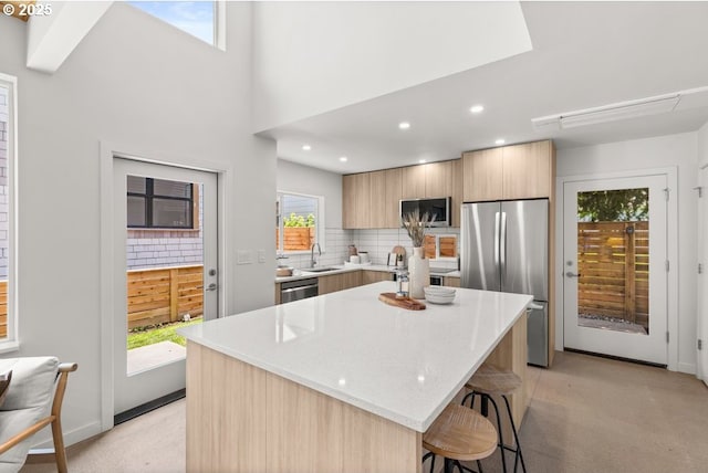 2415 NE 38th Ave Unit B, Portland, OR 97212 - kitchen featuring stainless steel appliances, modern cabinets, a kitchen bar, a kitchen island, and light carpet