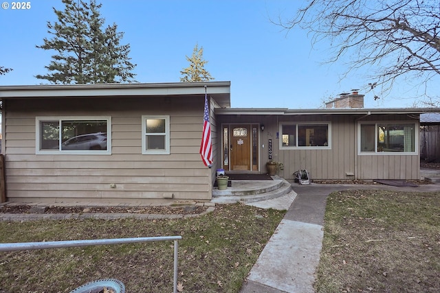 single story home with a chimney and fence