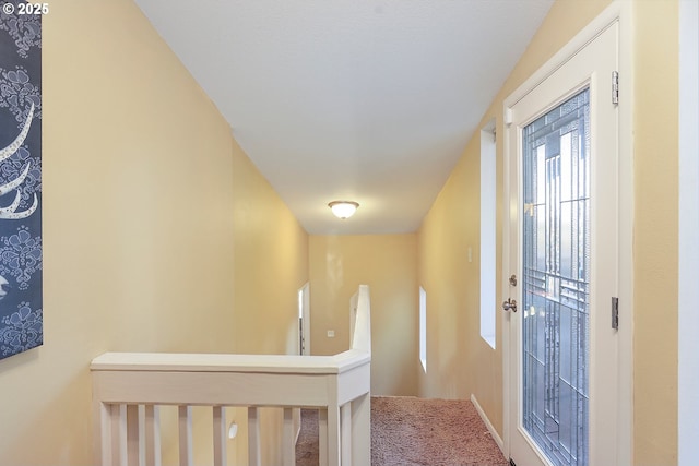 corridor with carpet and an upstairs landing