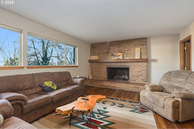 living area featuring a brick fireplace and wood finished floors