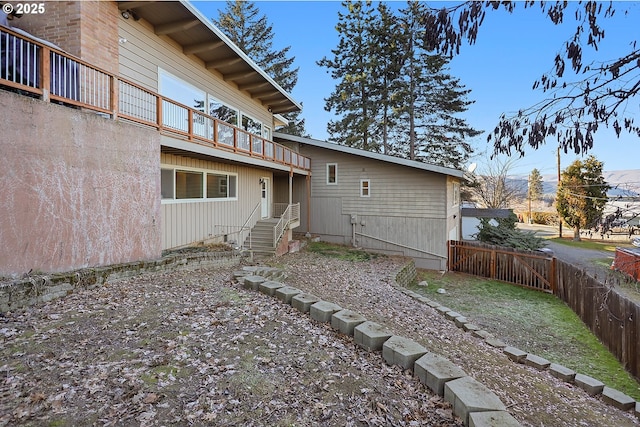 back of property with a balcony and fence