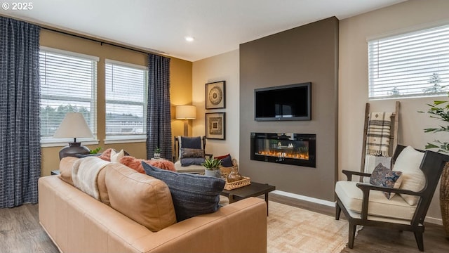 9336 SE Middleton St, Happy Valley, OR 97086 - living area featuring wood finished floors, a glass covered fireplace, healthy amount of natural light, baseboards, and recessed lighting