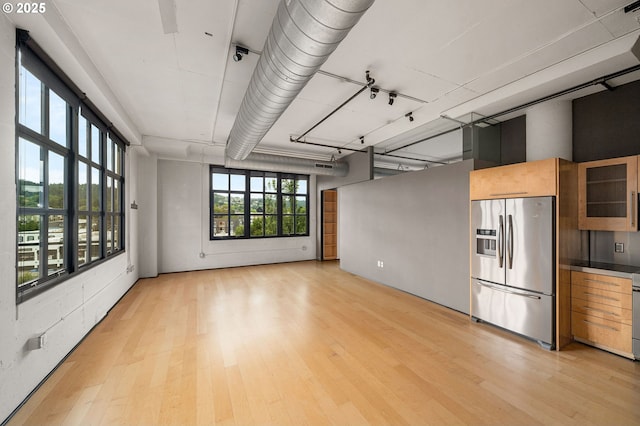 unfurnished room with light wood-type flooring and a high ceiling