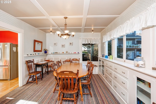 dining area with coffered ceiling and a notable chandelier