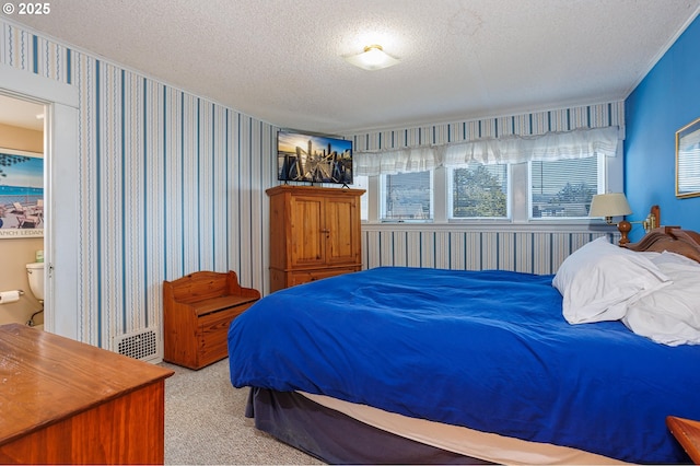 bedroom with light colored carpet and a textured ceiling