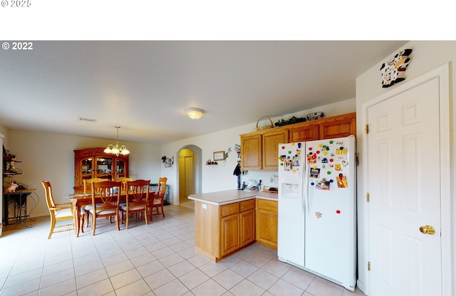 kitchen featuring visible vents, light countertops, a peninsula, white refrigerator with ice dispenser, and arched walkways