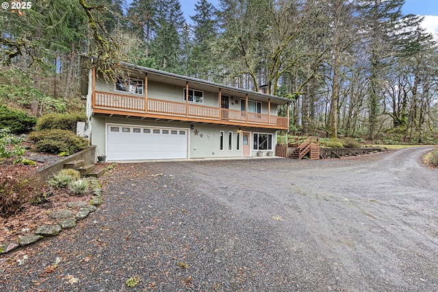 view of front of home featuring gravel driveway and a garage