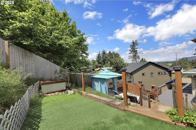 fenced backyard featuring exterior structure, an outdoor structure, and a deck
