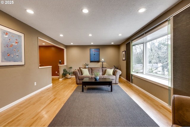 living room featuring recessed lighting, a textured ceiling, and light wood-style floors