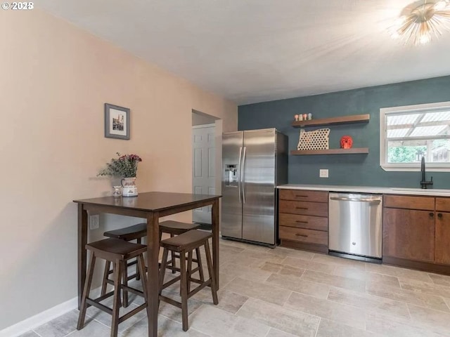 kitchen featuring sink, stainless steel appliances, and a breakfast bar